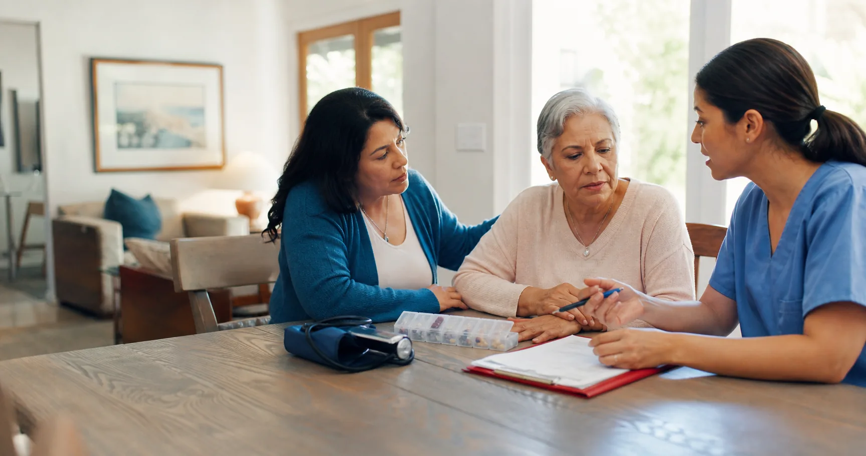 Home health nurse discussing a care plan with an older adult and family caregiver